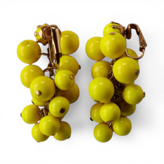 Reverse view of chartreuse glass bead cluster earrings showing gold-tone hinged clip-on fasteners and individual bead pin ...