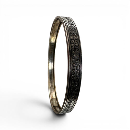 Interior of Coro sterling silver bangle showing smooth rounded surface, natural silver toning, and concealed box clasp wit...