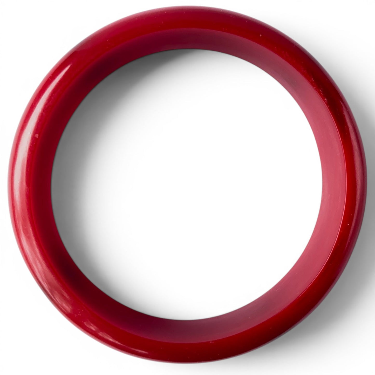 Interior bore view of both cherry red Bakelite bangles showing smooth rounded inner surface and light wear marks consisten...