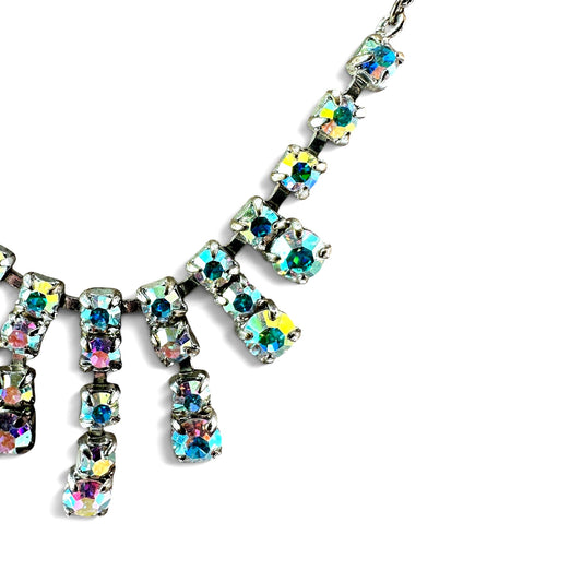 Close-up of aurora borealis rhinestones showing iridescent teal, lavender, and pink flash in open-back cup prong settings