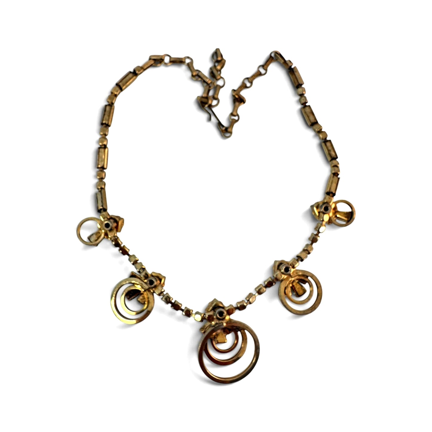 Overhead flat-lay of complete gold-tone rhinestone pendant necklace showing all five drop stations and full chain length