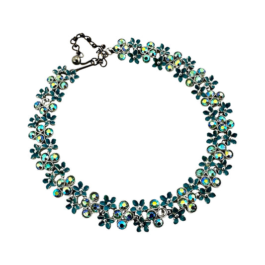 Close-up of alternating teal enamel daisy stampings and iridescent AB rhinestones in prong cup settings on Kramer collar n...