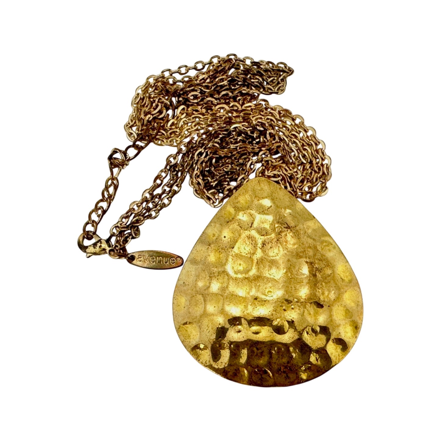 Reverse side of Avenue brass teardrop pendant showing hammered dimple texture with rounded impressions across surface