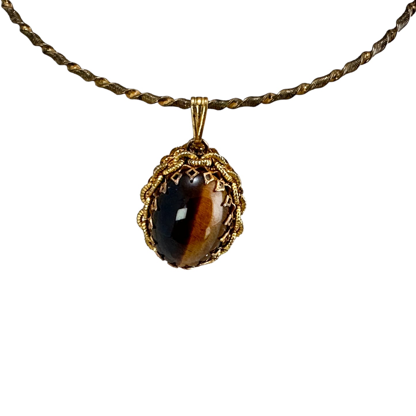 Close-up of Haskell pendant showing diamond-cutout bezel edge, rope-work gilt metal setting, and warm amber Tiger's Eye stone
