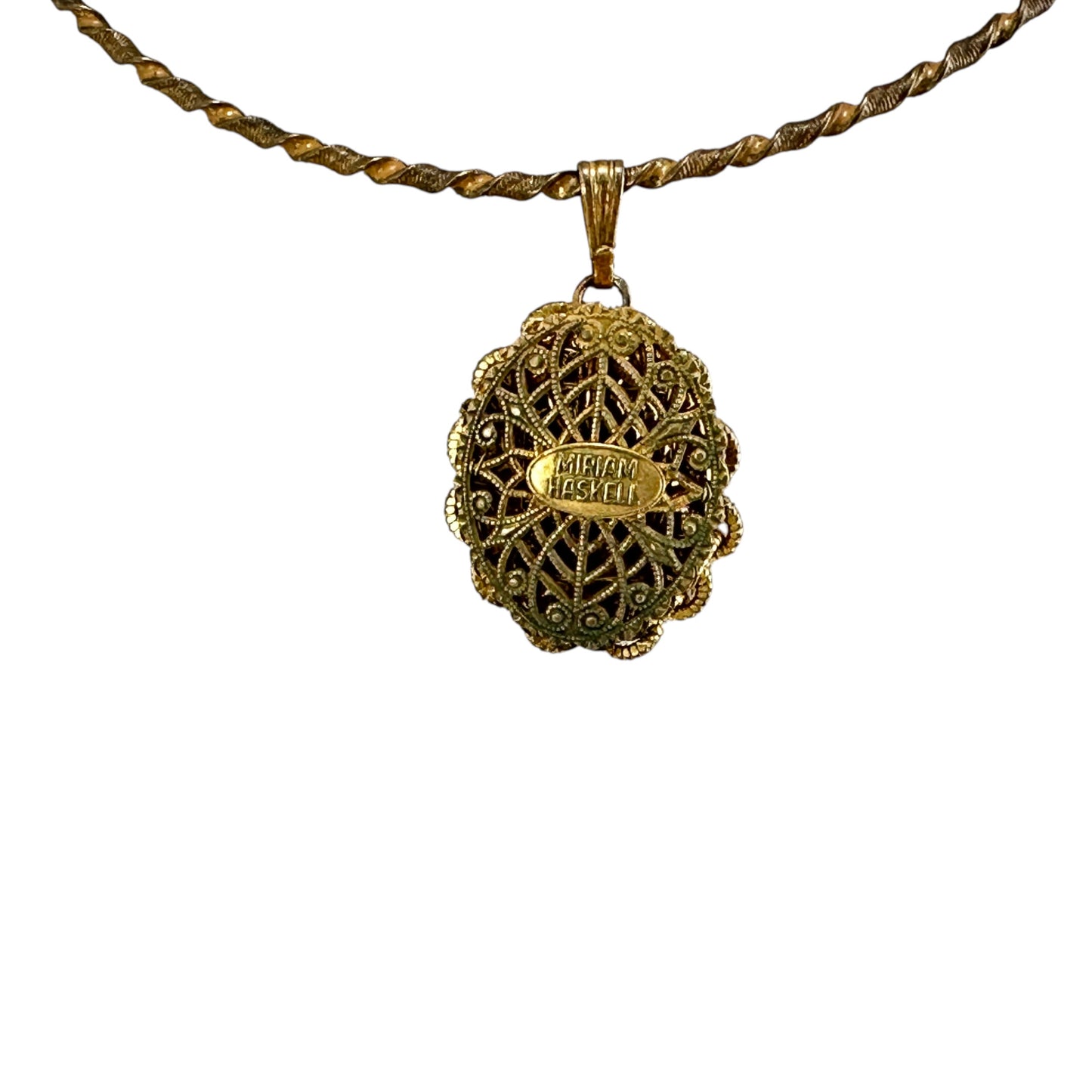 Reverse of Miriam Haskell pendant showing open oval filigree backing with oval signature plaque riveted at center