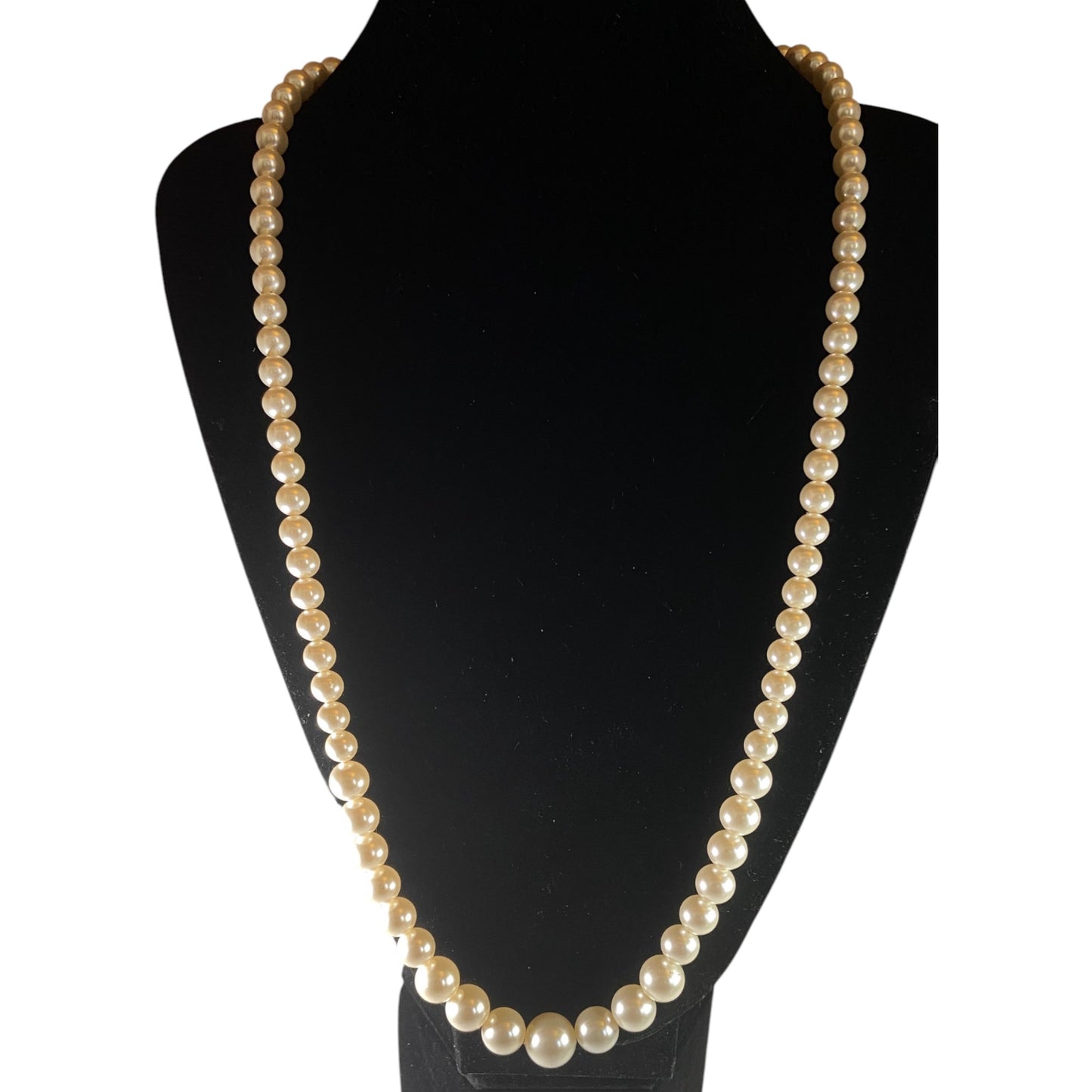 Single-strand graduated faux pearl necklace displayed on black velvet bust, signed Marvella gold-tone barrel clasp visible