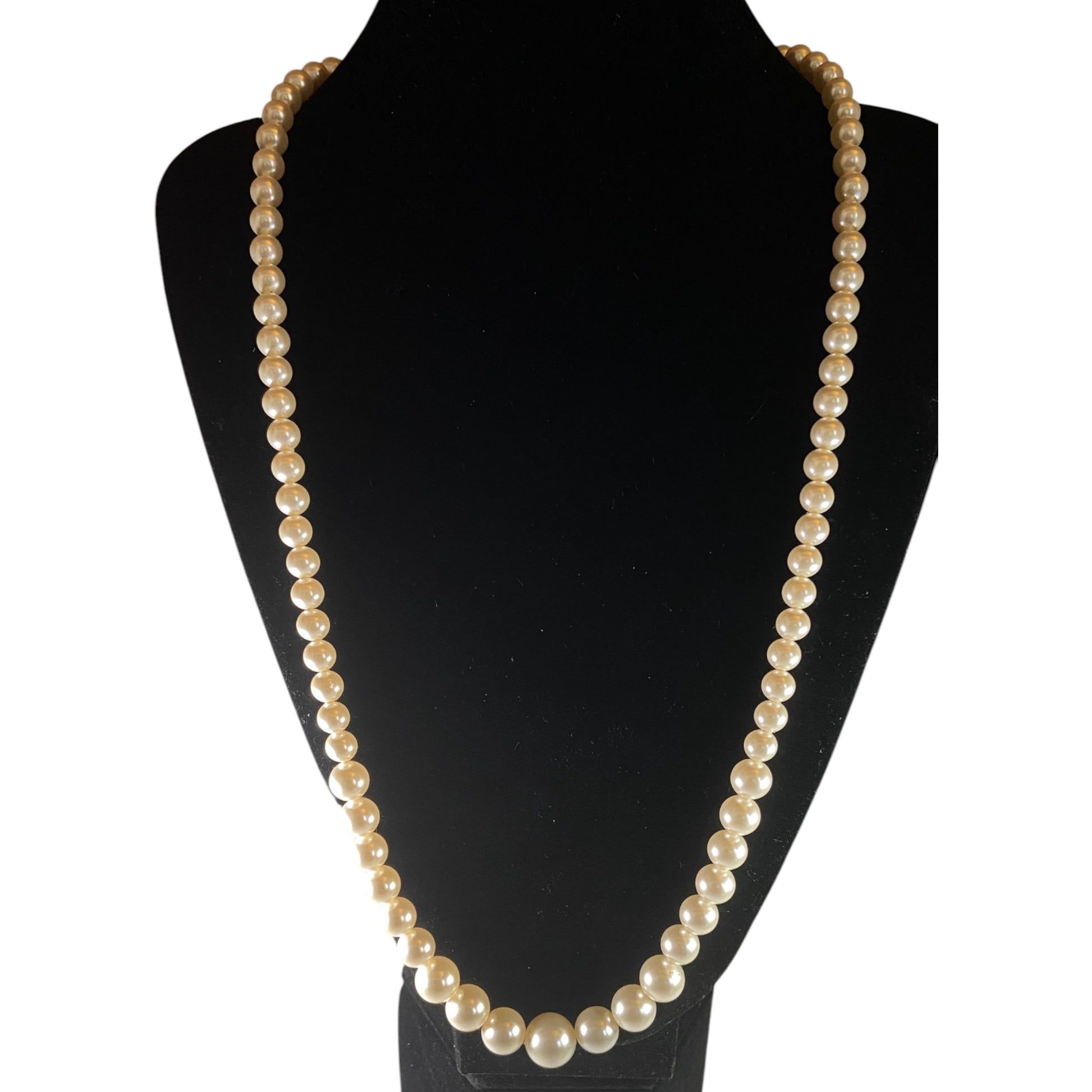 Single-strand graduated faux pearl necklace displayed on black velvet bust, signed Marvella gold-tone barrel clasp visible