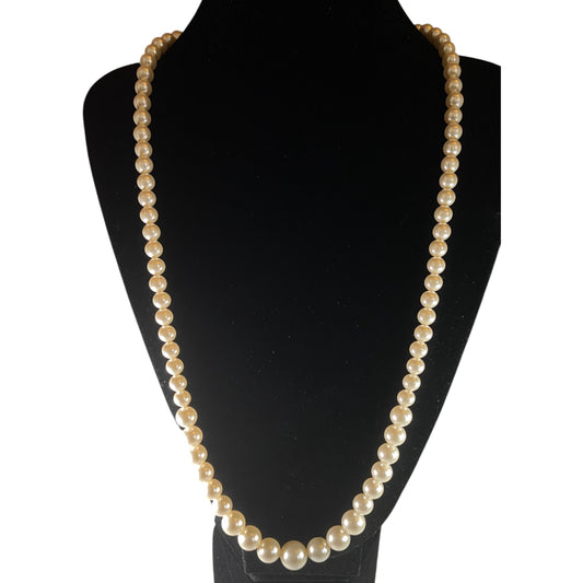 Single-strand graduated faux pearl necklace displayed on black velvet bust, signed Marvella gold-tone barrel clasp visible