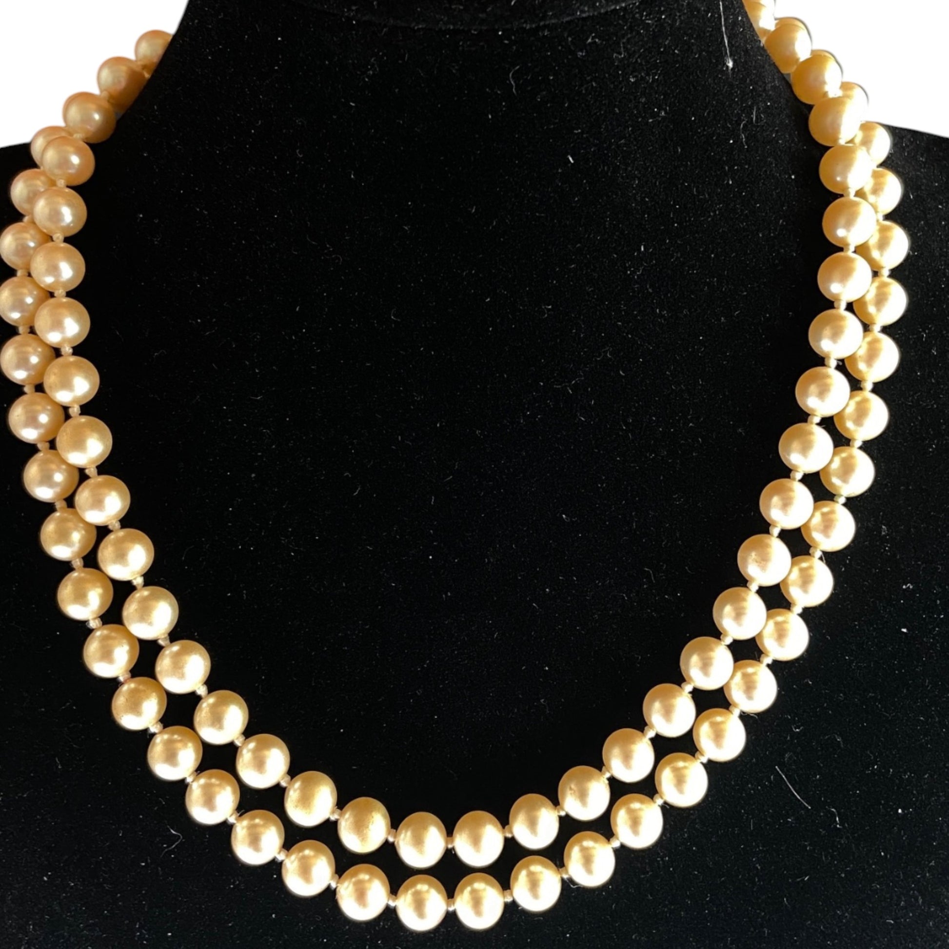  cream faux pearl necklace displayed on black velvet bust form, approx. 36 inches in length