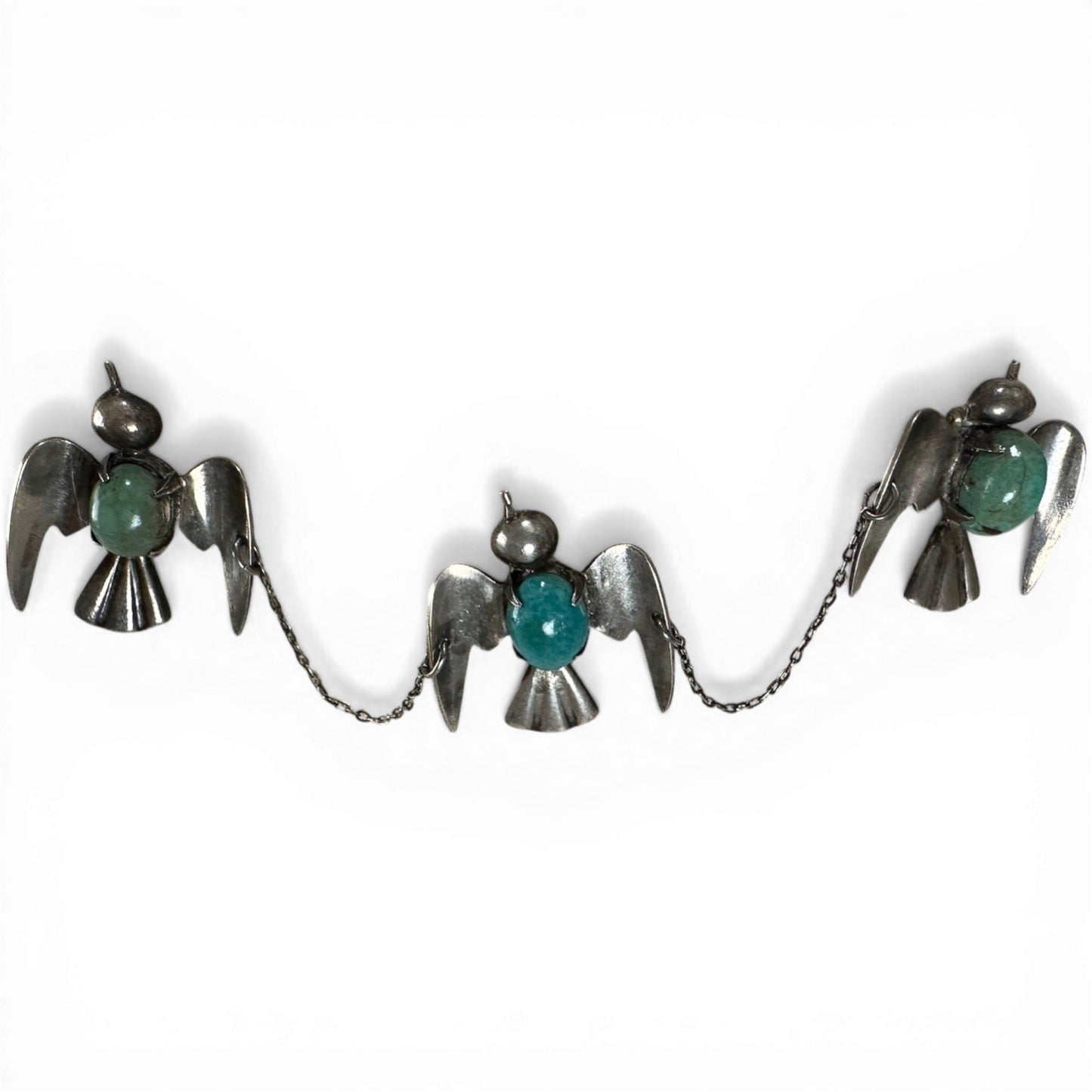 Three linked sterling silver bird brooches with bezel-set turquoise cabochons and fine rolo chain connections, front view