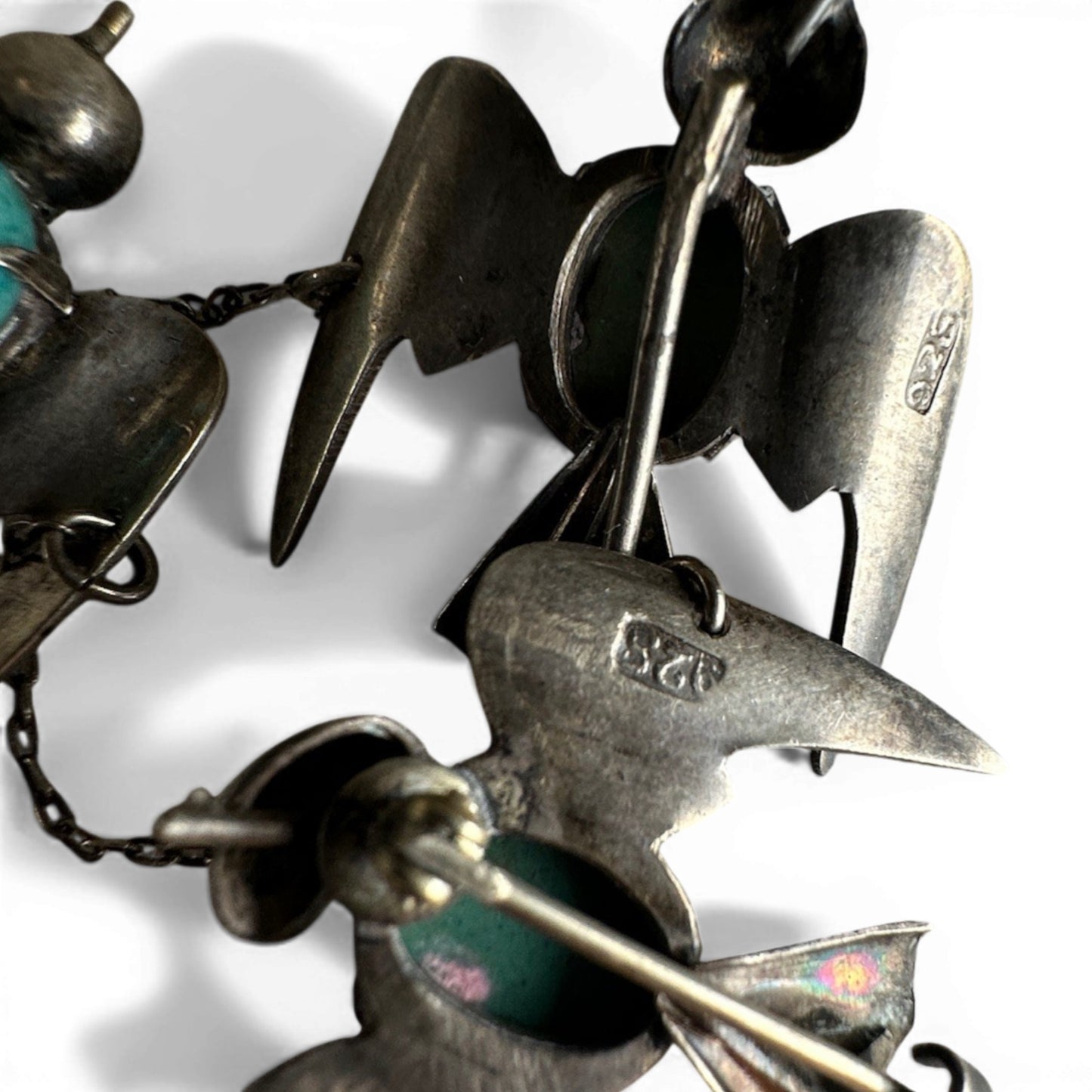 Detail of 925 sterling silver stamp and rolled pin stem finding on reverse of bird brooch figure