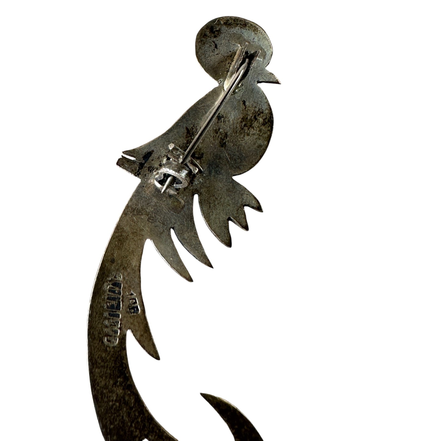 Close-up of hand-chased geometric and feather-like surface texture on sterling silver bird brooch body and tail