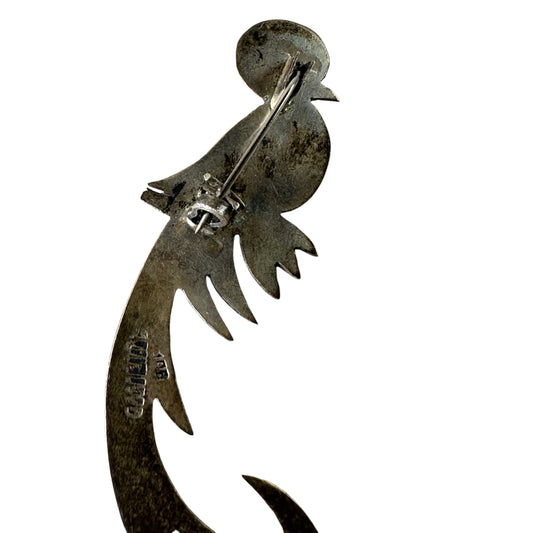 Close-up of hand-chased geometric and feather-like surface texture on sterling silver bird brooch body and tail
