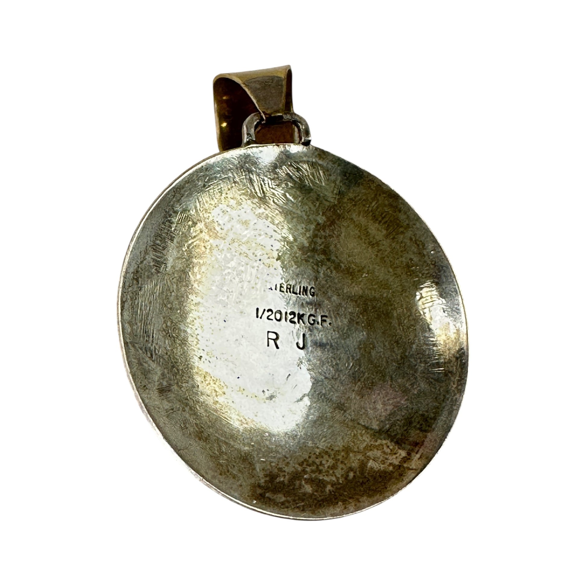 Reverse of domed sterling silver pendant showing STERLING, 1/20 12K G.F., and R J hallmarks