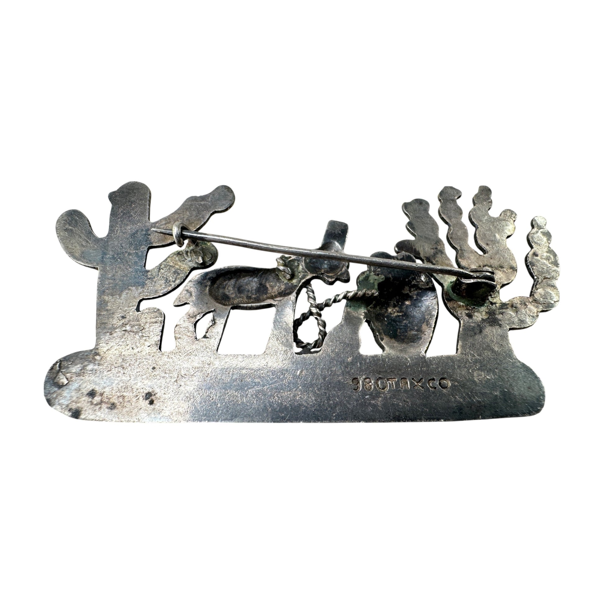 Reverse of TAXCO 980 silver brooch showing rollover C-clasp pin stem, solder joints, and aged patina with green verdigris ...