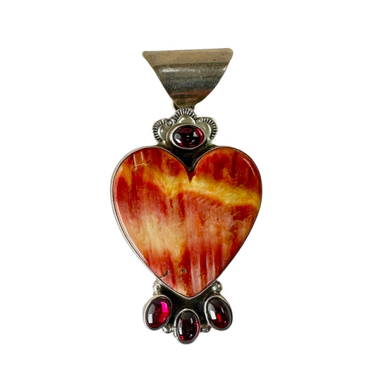 Close-up of oval garnet cabochons set above and below spiny oyster shell in sterling silver heart pendant by LB
