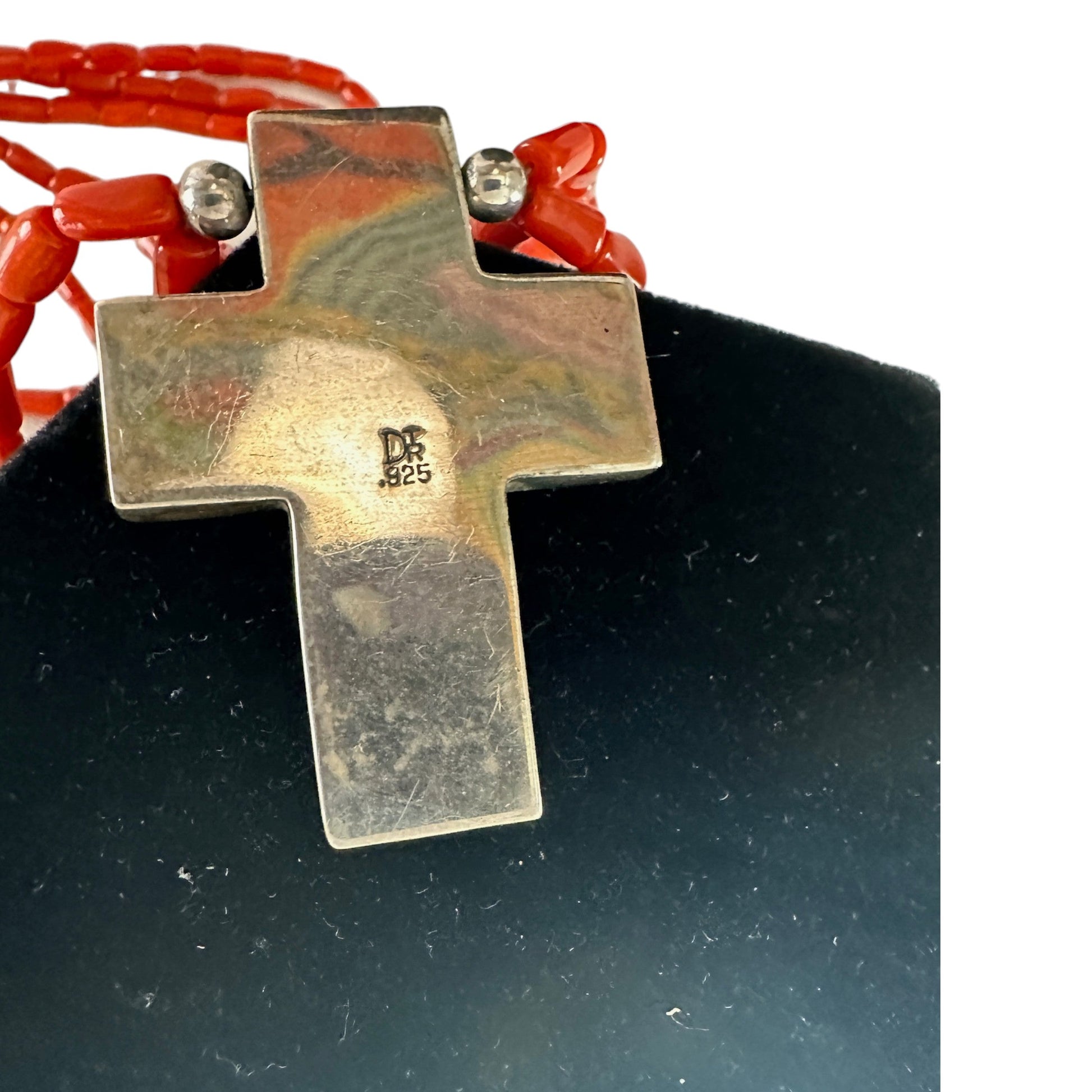 Back of three-strand coral necklace showing large domed silver end caps, wire wrapping, lobster claw clasp and oval link e...