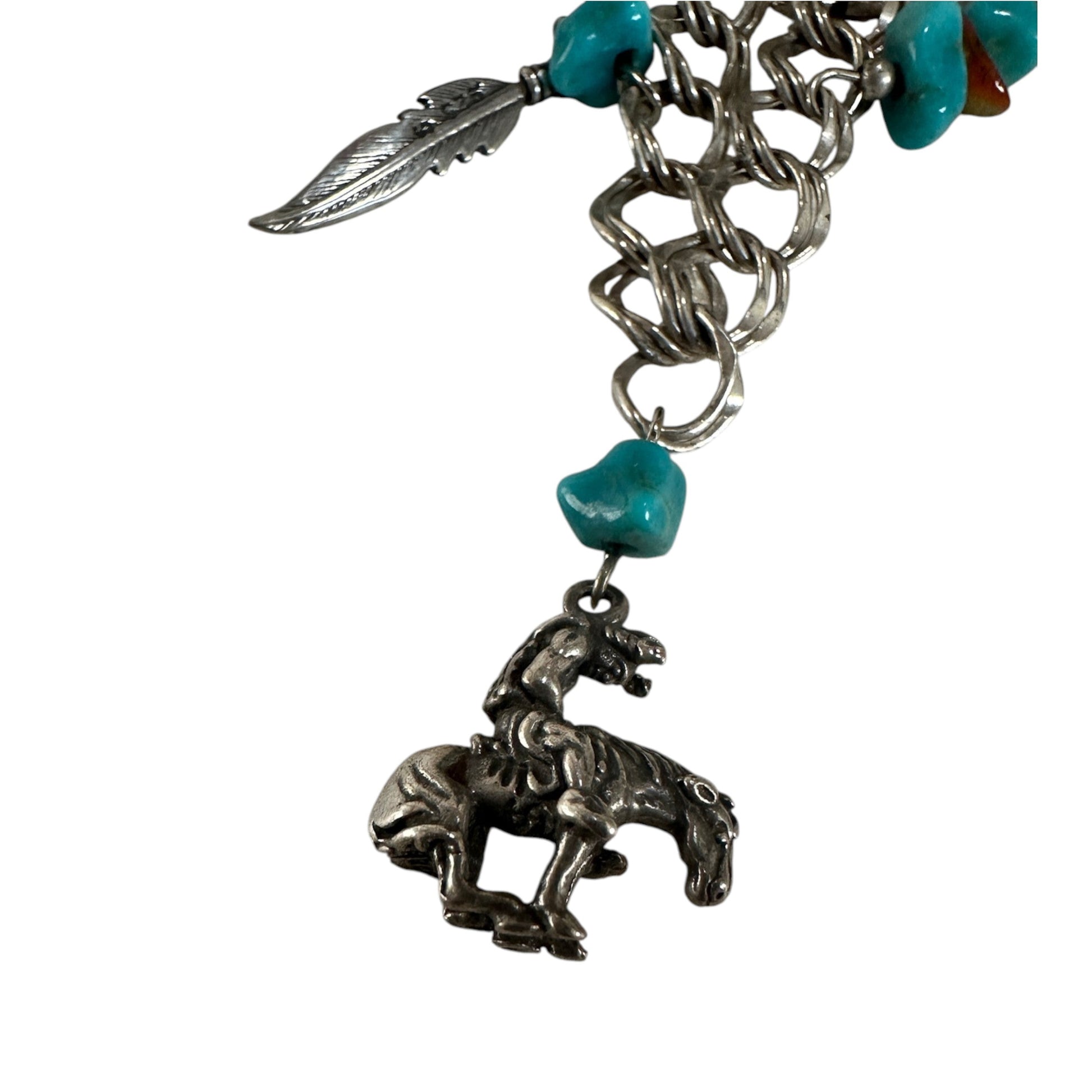 Sterling silver Southwestern charm necklace by ST showing rearing horse, bull skull, cactus, and feather charms with orang...
