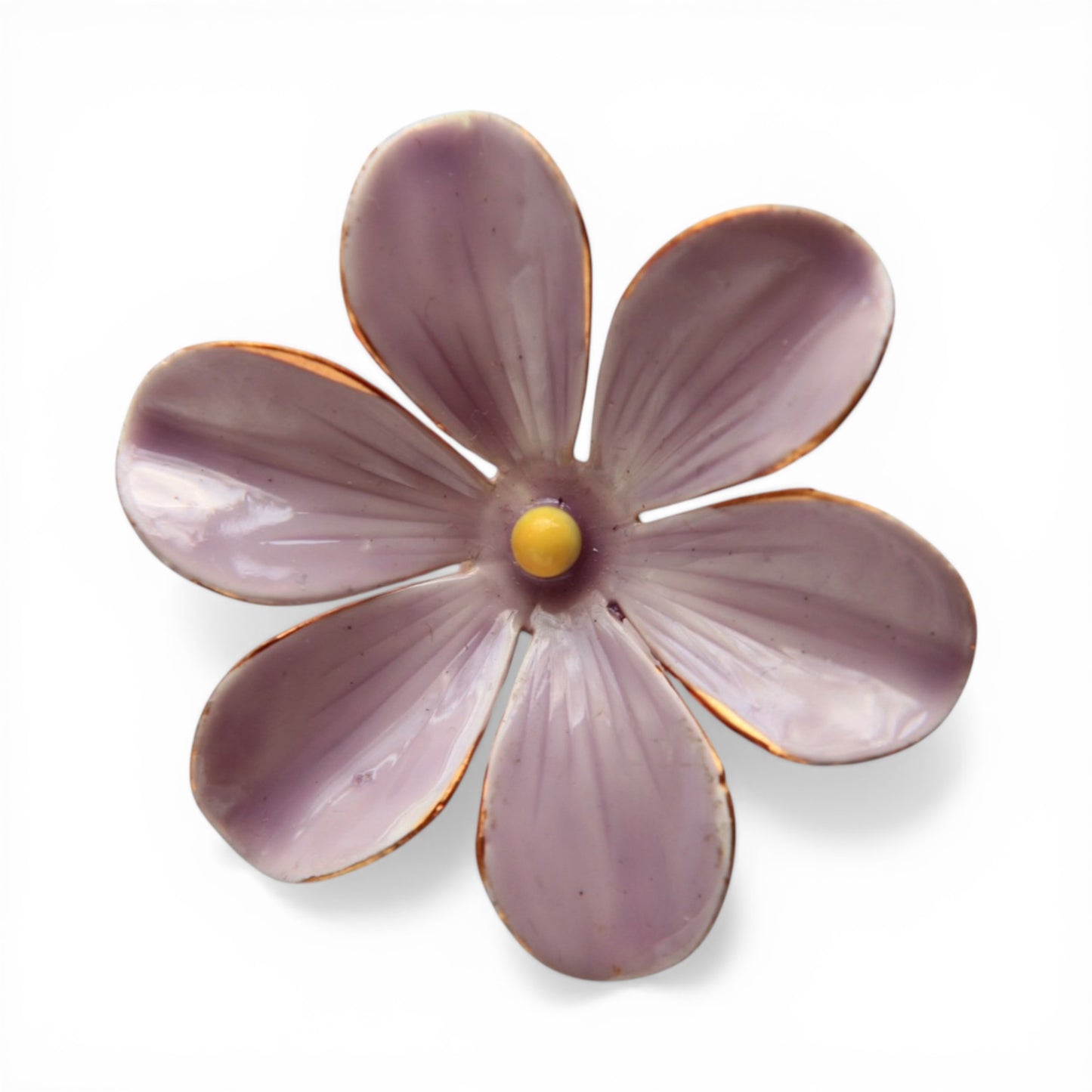 Six-petal lavender enamel flower brooch with copper-gilt metal edges and yellow enamel center stamen, front view