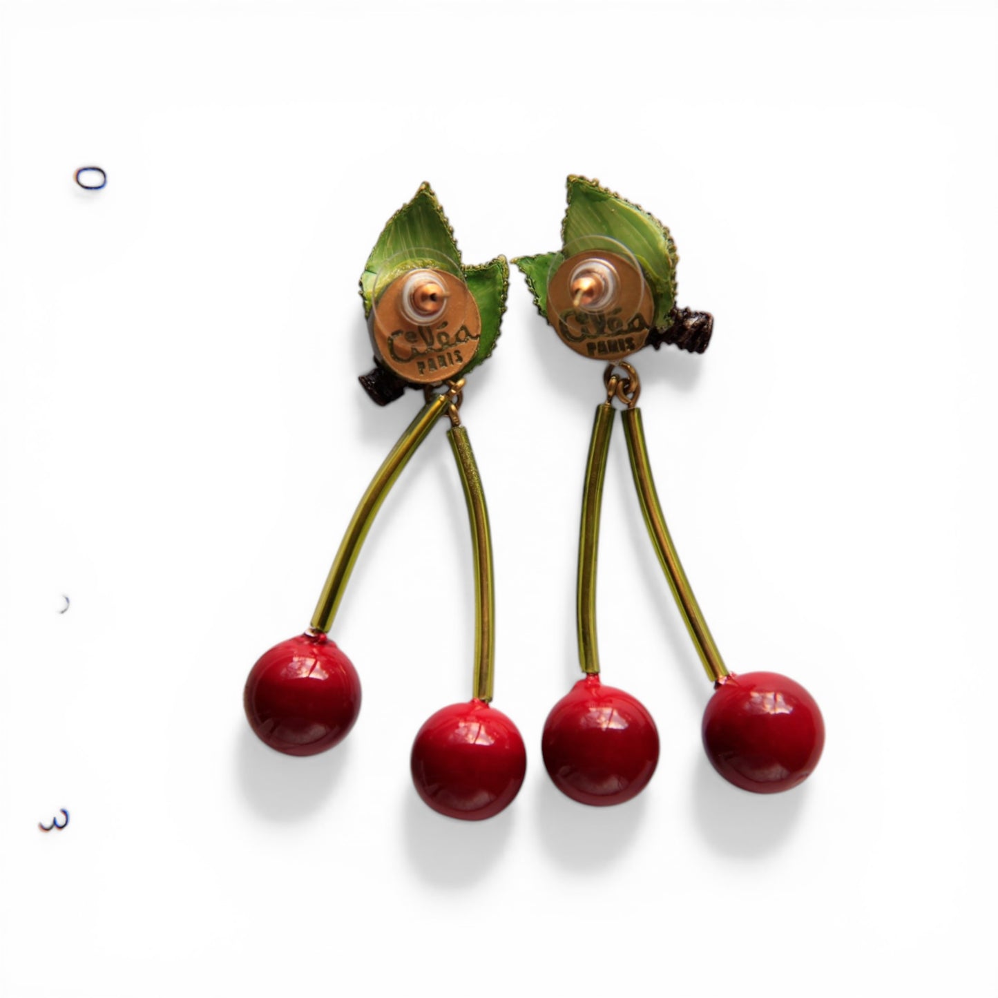 Reverse view of Cilea Paris cherry pierced earrings showing copper-tone clip mechanisms with oval maker's stamp