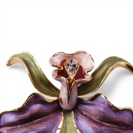 Close-up of orchid brooch centre column showing teardrop rhinestone setting with three prong-set clear stones against pink...