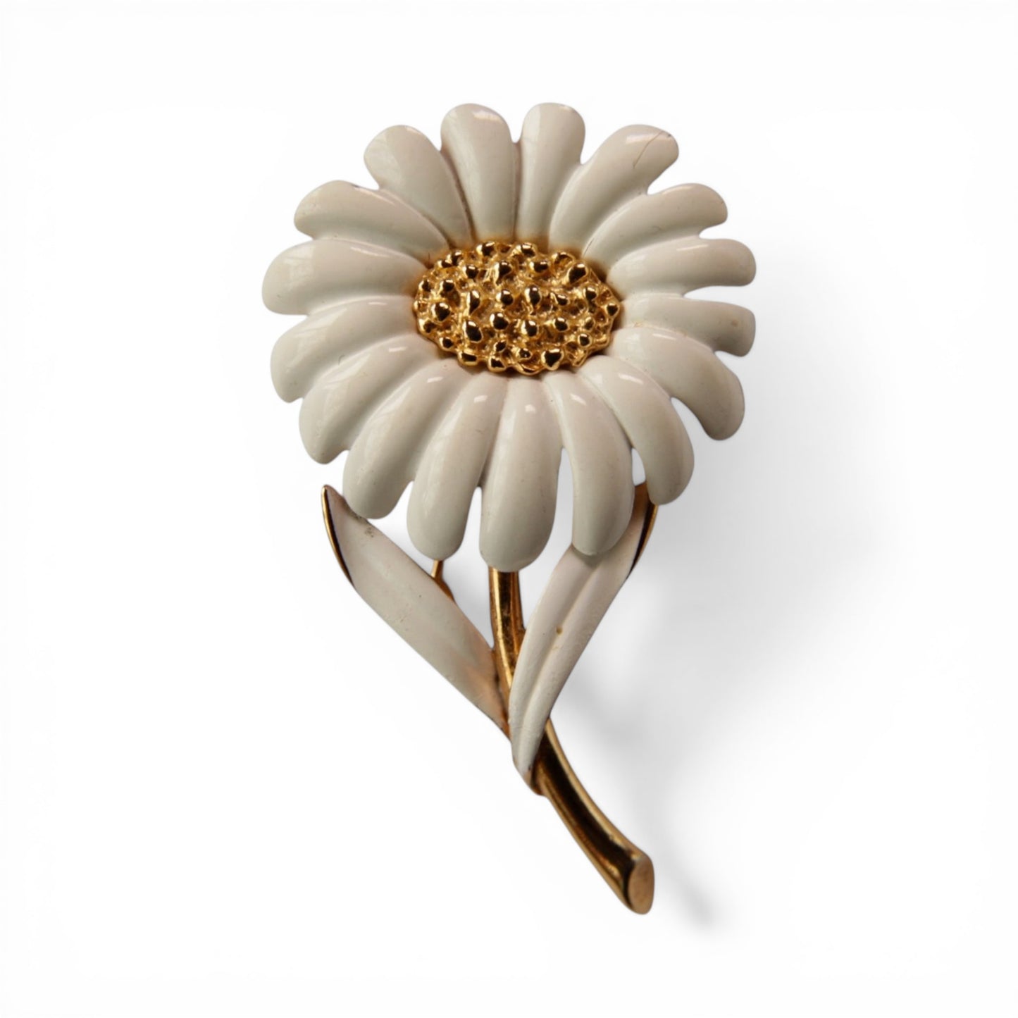 MONET signed daisy brooch with white enamel petals, textured gold-tone domed center, and gold-tone stem with two white ena...