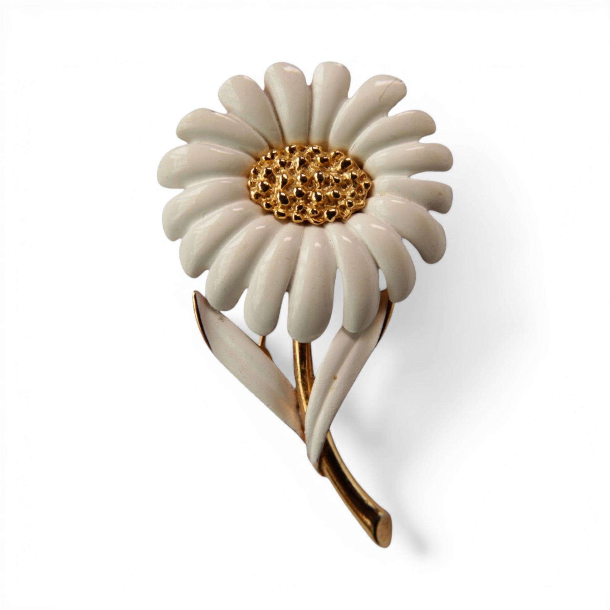 MONET signed daisy brooch with white enamel petals, textured gold-tone domed center, and gold-tone stem with two white ena...