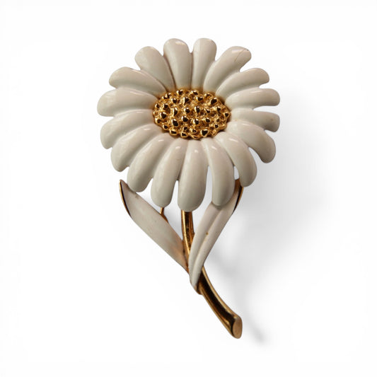 MONET signed daisy brooch with white enamel petals, textured gold-tone domed center, and gold-tone stem with two white ena...
