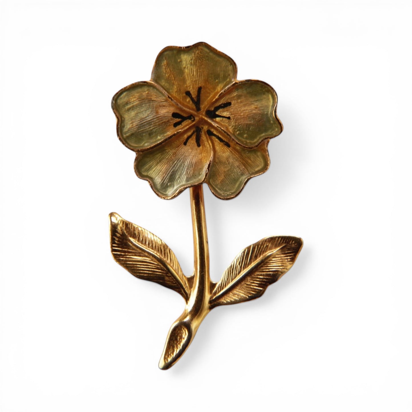 Gold-tone five-petal flower brooch with pale sage green enamel fill, black accent lines, engraved leaves, stem, and small ...