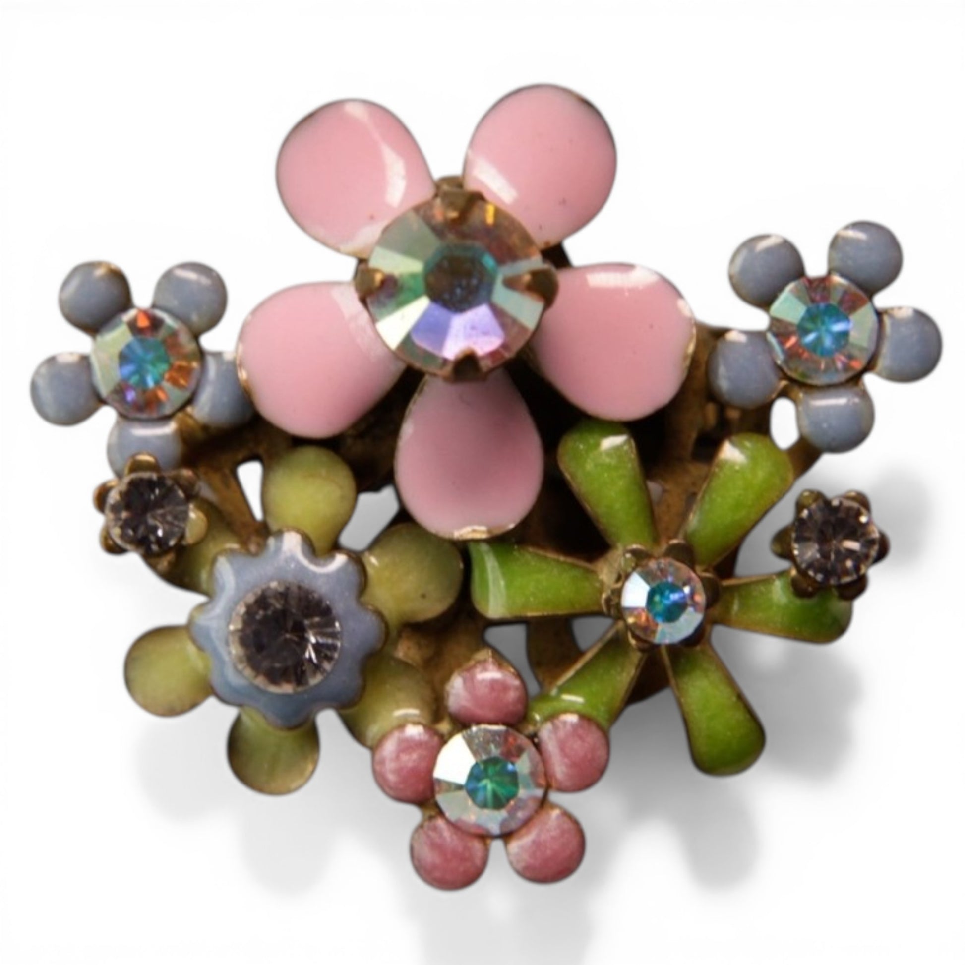 Three-dimensional cluster brooch with pink and lavender-gray cabochon daisy flowers on green enamel star bases, aurora bor...