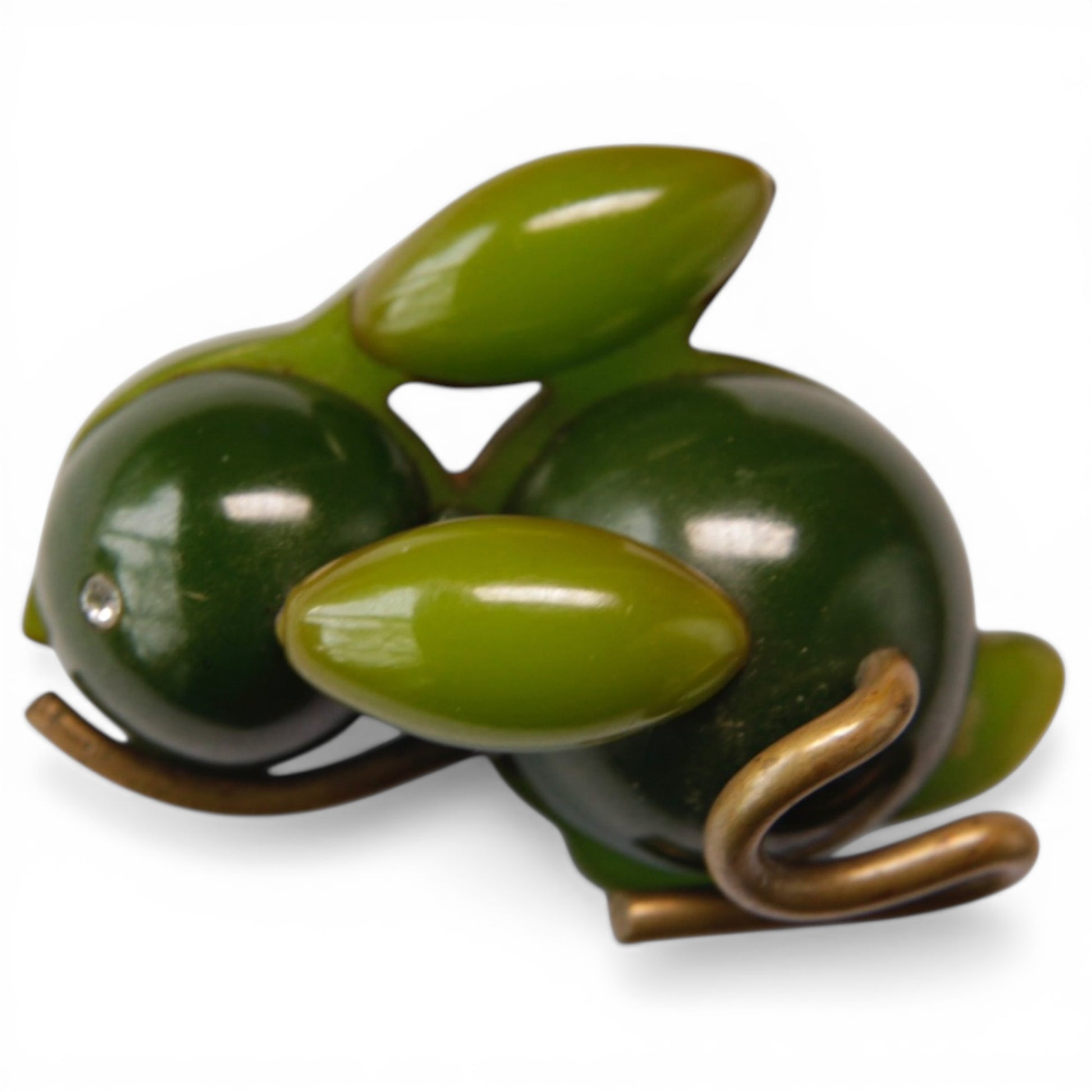 Close view of Bakelite rabbit brooch showing brass wire coiled tail, shaped brass feet, and single rhinestone eye detail