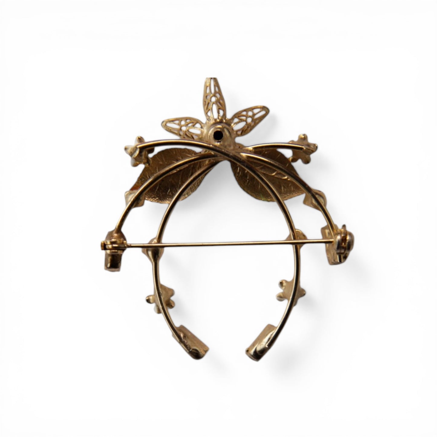 Reverse of gold-tone horseshoe brooch showing horizontal pin-stem bar clasp with C-catch and open-back prong stone settings