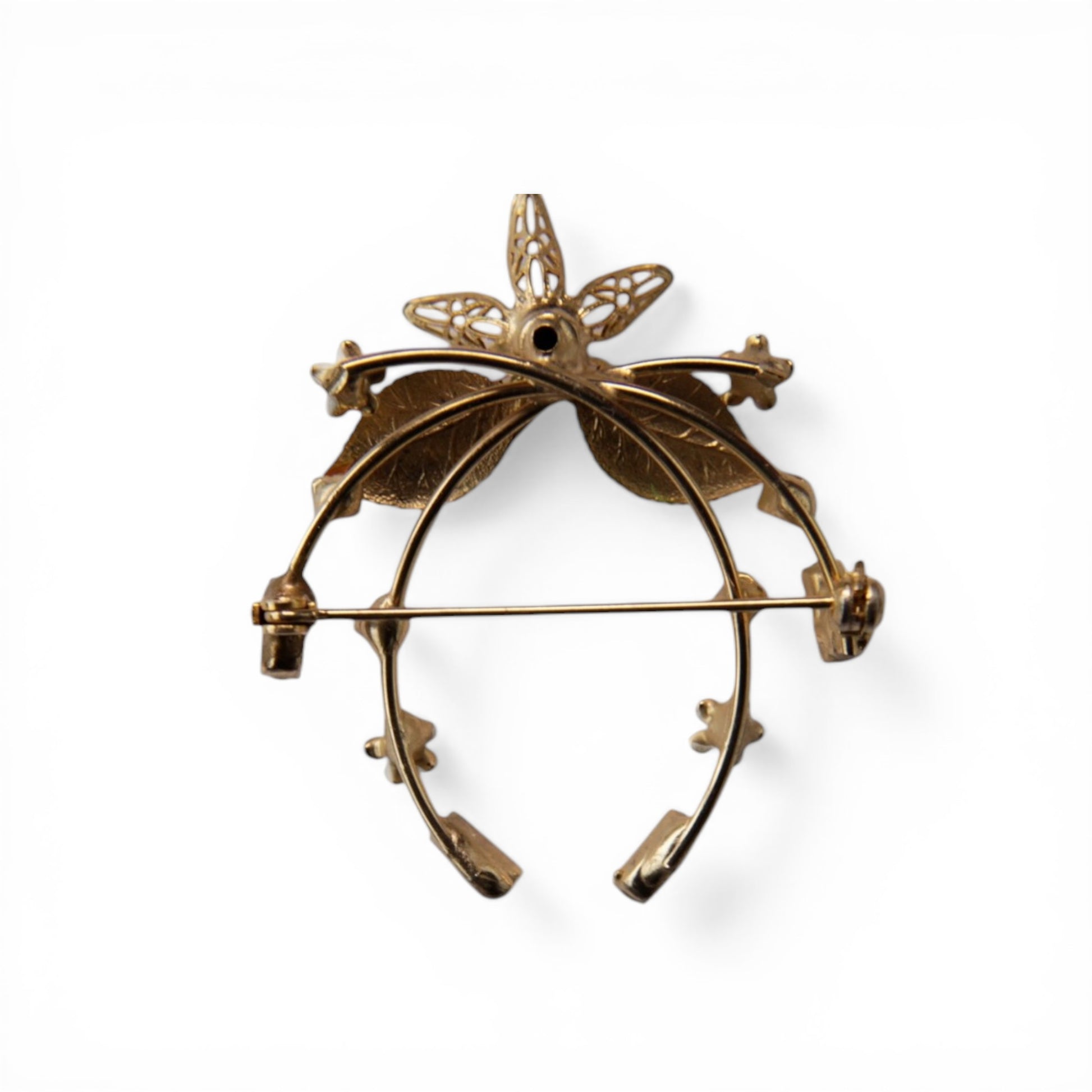 Reverse of gold-tone horseshoe brooch showing horizontal pin-stem bar clasp with C-catch and open-back prong stone settings