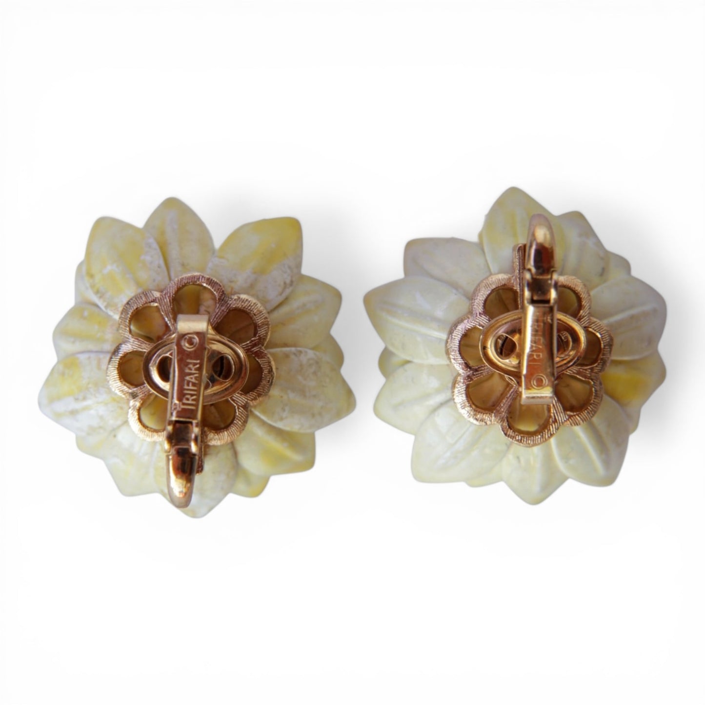 Reverse of TRIFARI clip-on earrings showing scalloped gold-tone back plate with TRIFARI copyright mark stamped on clip bar
