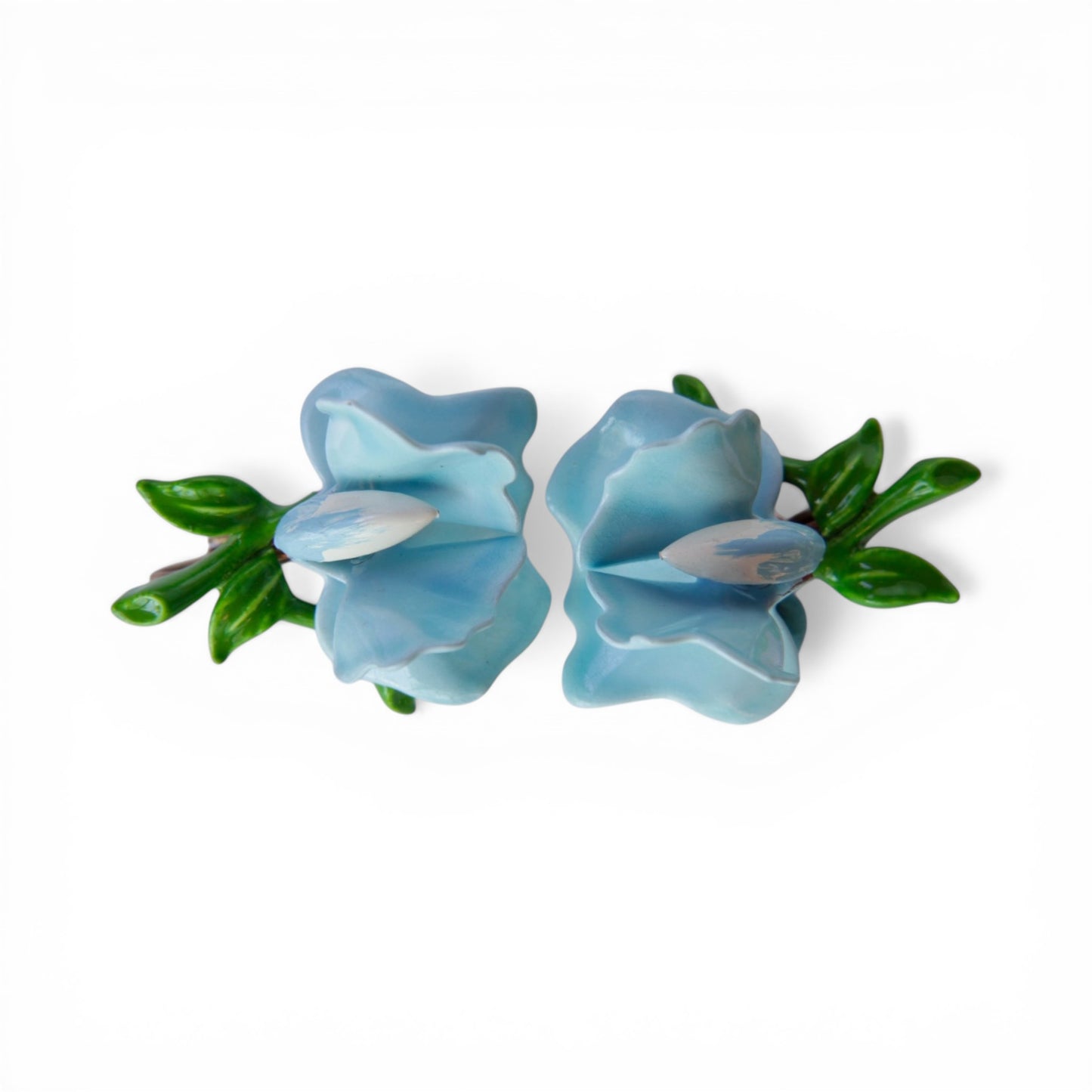 Pair of three-dimensional powder blue Lucite flower clip-on earrings with glossy green enamel leaf and bud detail, front view
