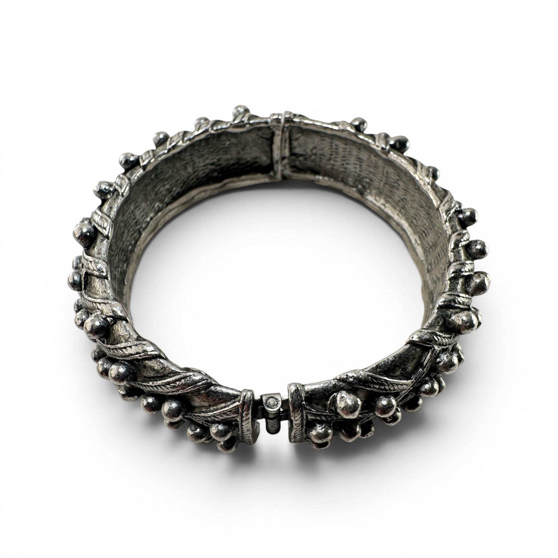 Interior view of Hattie Carnegie cuff bangle showing rough bark-like cast texture and oval script signature cartouche