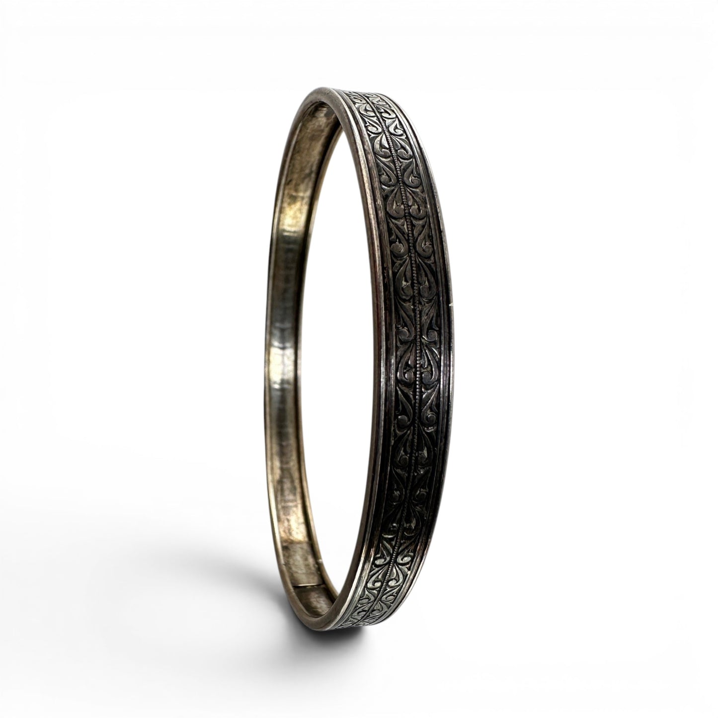 Interior of Coro sterling silver bangle showing smooth rounded surface, natural silver toning, and concealed box clasp wit...