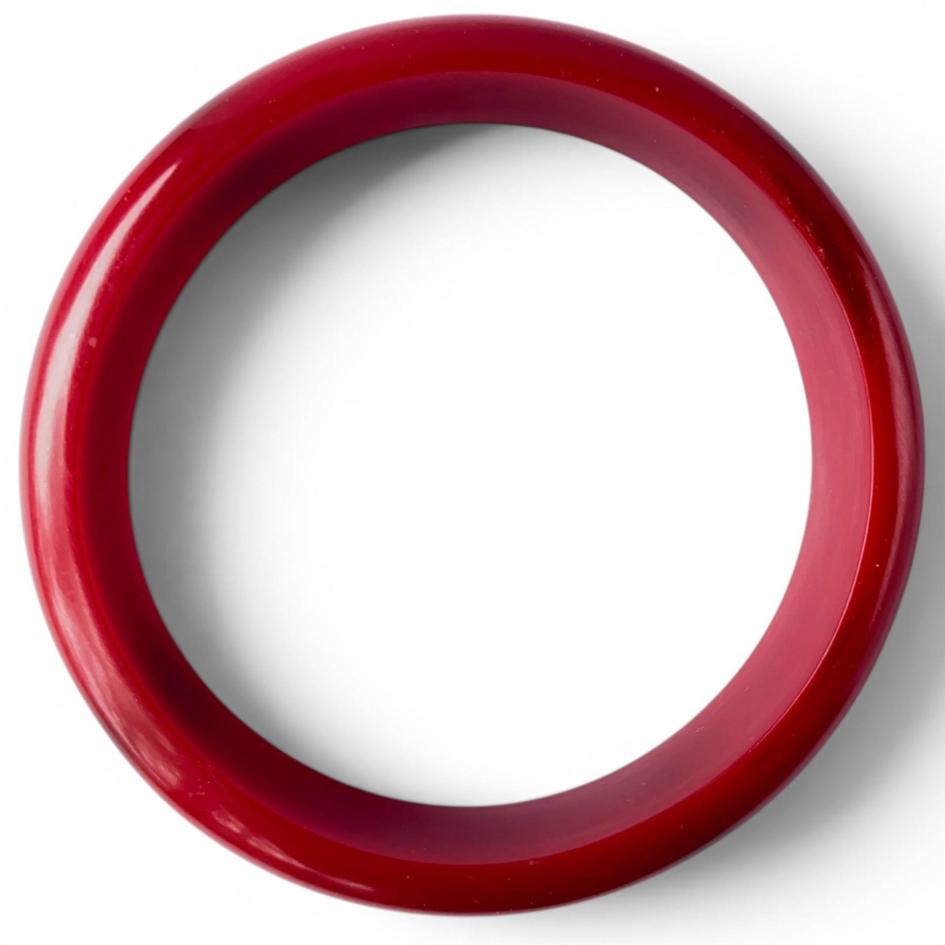 Interior bore view of both cherry red Bakelite bangles showing smooth rounded inner surface and light wear marks consisten...