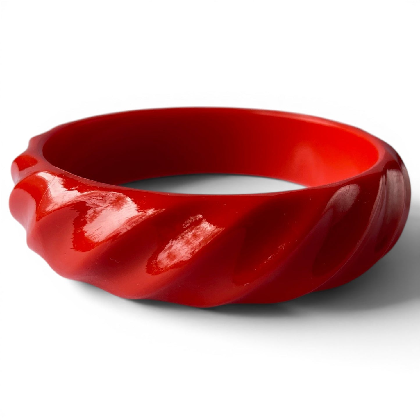 Cherry red Bakelite bangle bracelet with diagonal rope-twist carved exterior relief pattern, high-gloss finish, solid slip...