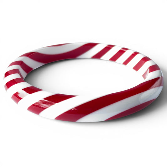 Chunky tubular bangle bracelet with continuous red and white diagonal candy-stripe pattern, high-gloss finish, seamless cl...