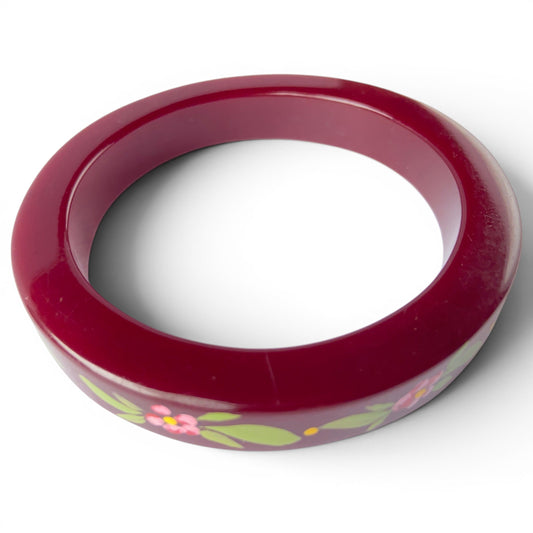 Side-angle view of burgundy lacquered bangle showing slightly squared cross-section profile and glossy painted surface