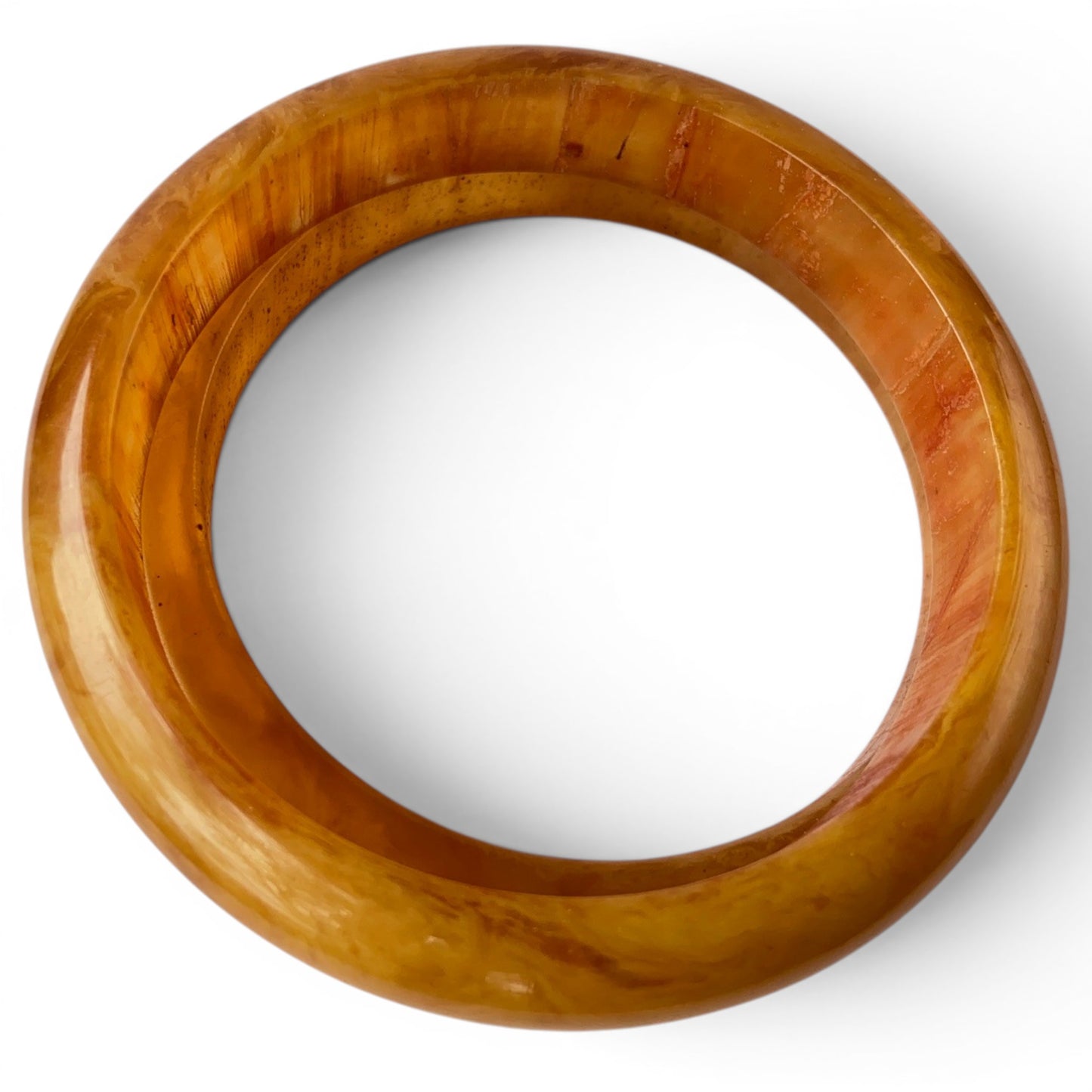 Side view of two solid Bakelite slip-on bangles displaying rounded convex outer profile and smooth inner bore, no clasp or...