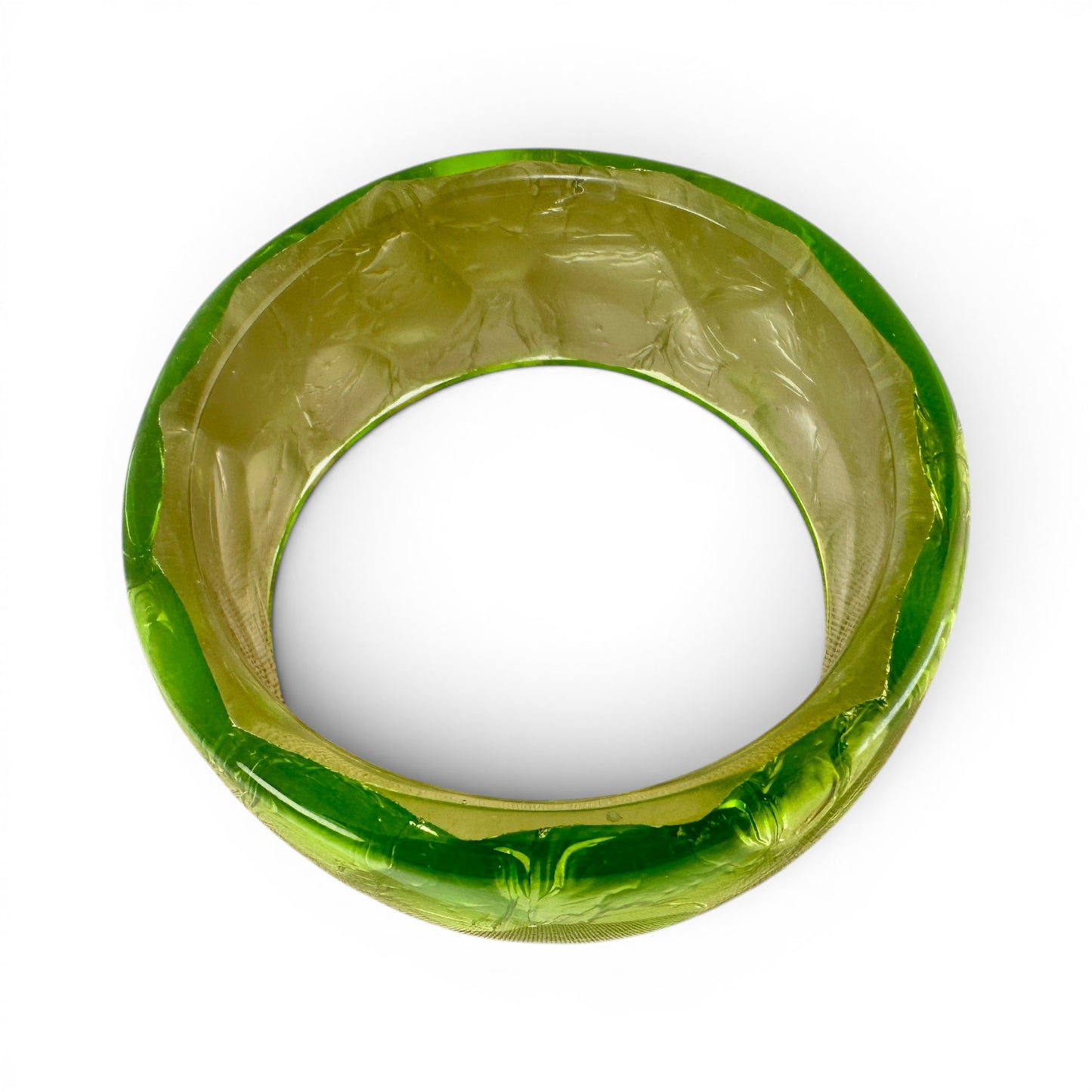 MCM-Mid Century Modern era slip-on bangle in transparent resin with green metallic foil interior, smooth cylindrical inner bore visible, angl...