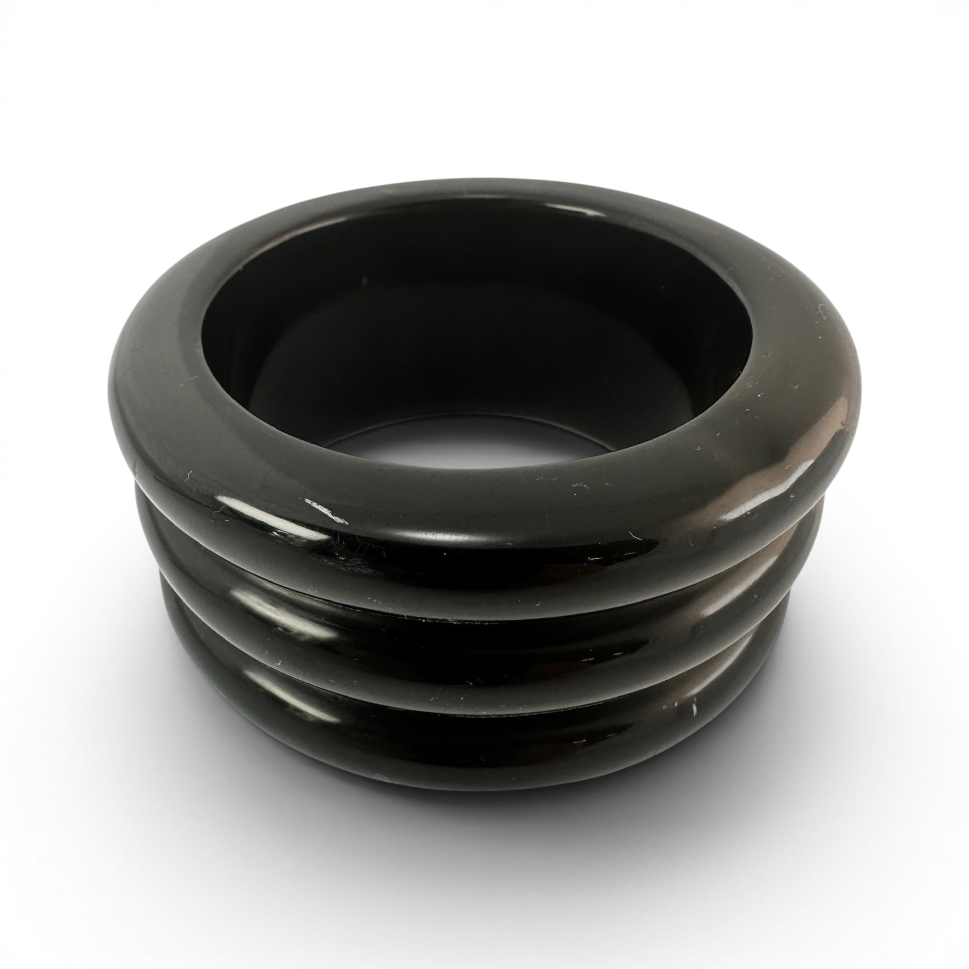 Black Bakelite bangle bracelet with three raised horizontal ridges on exterior, high-gloss polish, rigid slip-on construct...