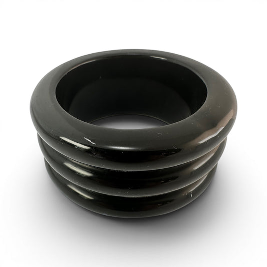 Black Bakelite bangle bracelet with three raised horizontal ridges on exterior, high-gloss polish, rigid slip-on construct...