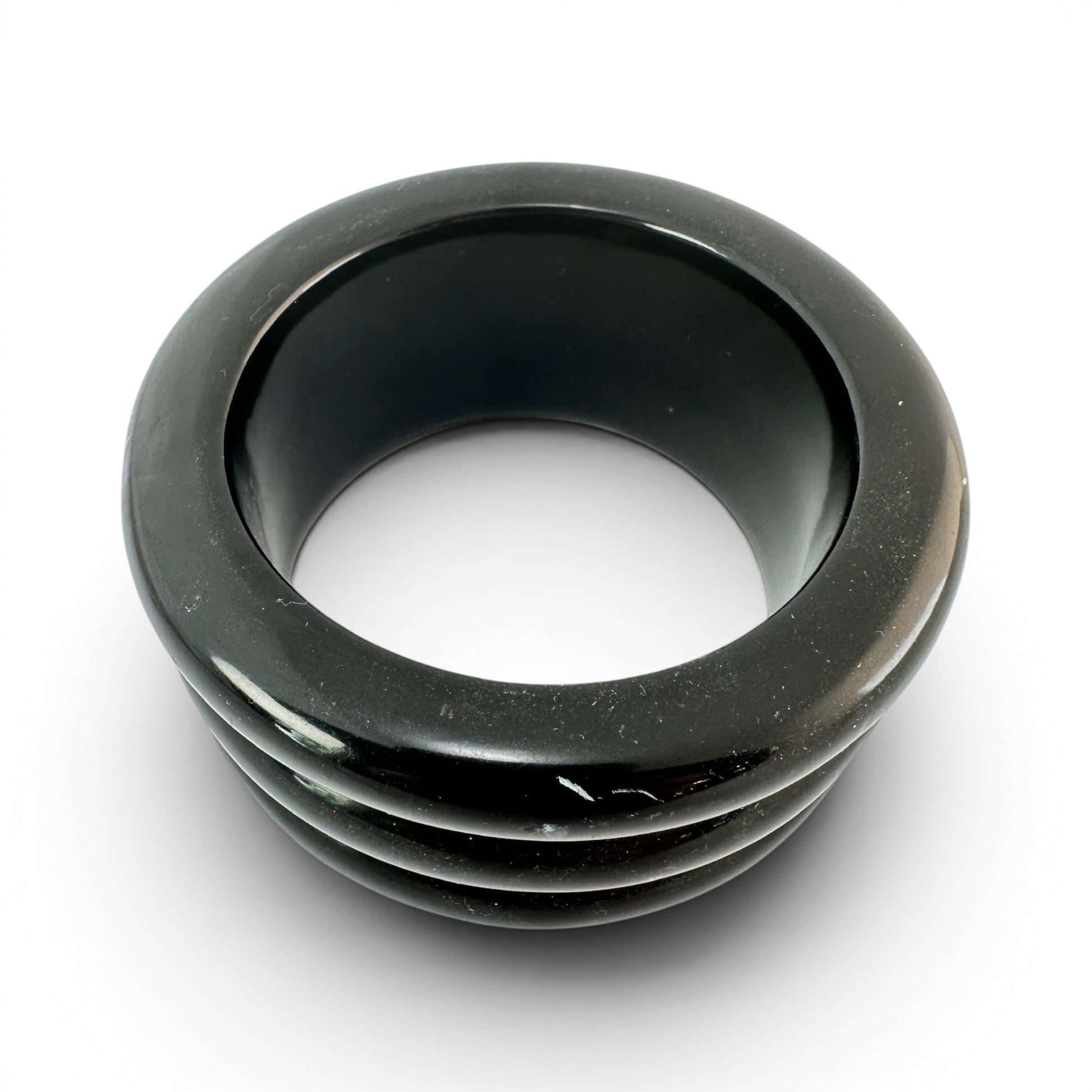 Top-down view of black Bakelite slip-on bangle showing circular form, glossy finish, and ribbed exterior detail