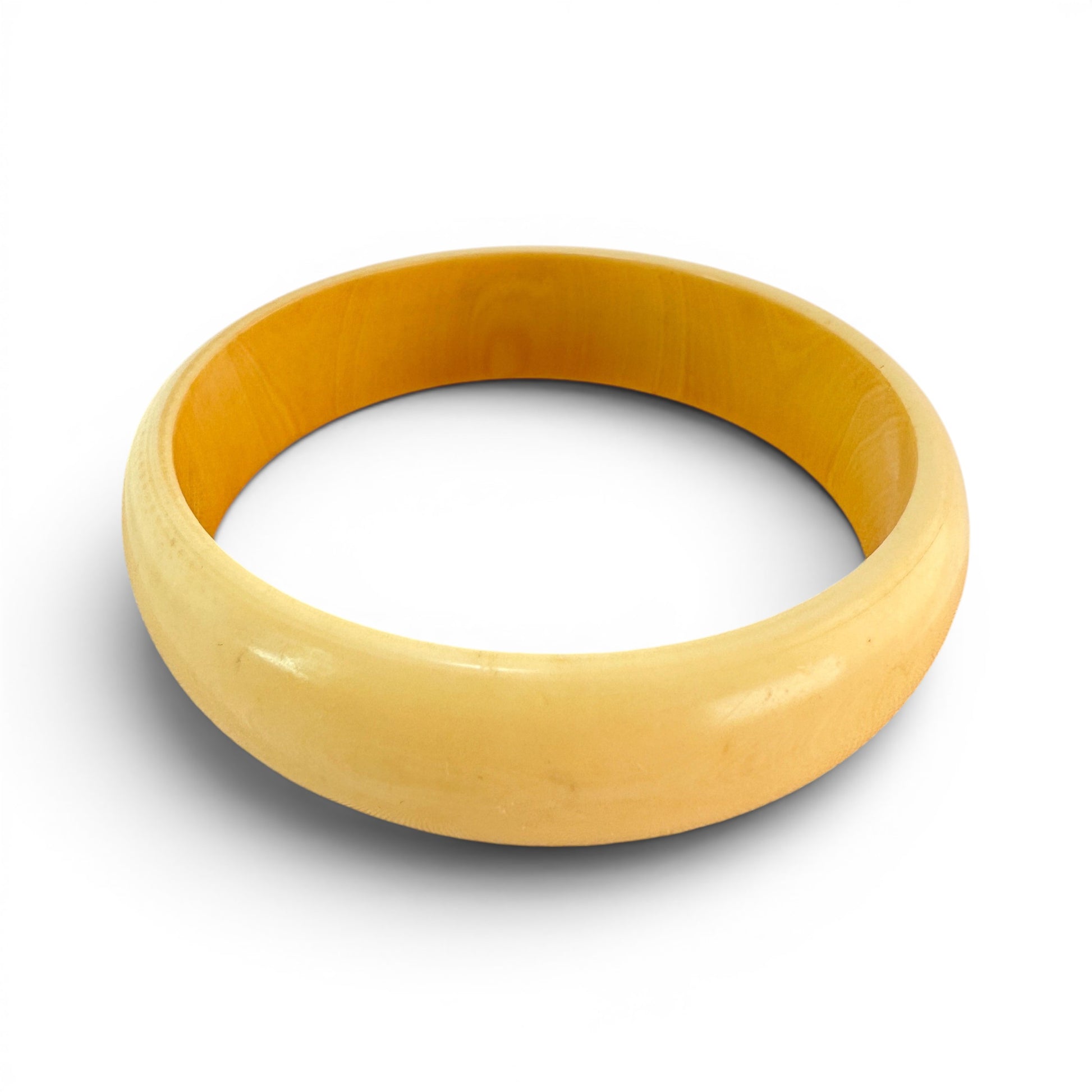 Interior view of cylindrical unadorned smooth inner wall of solid one-piece butterscotch Bakelite bangle