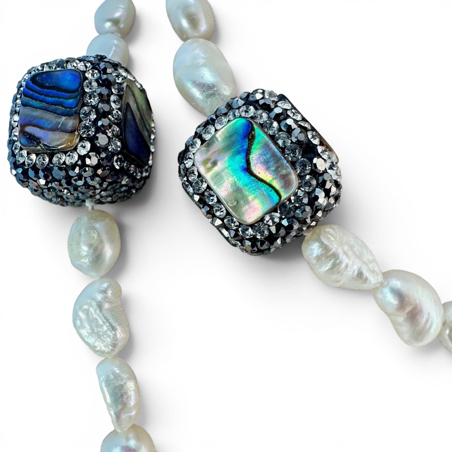 Necklace styled doubled at shorter length showing two-strand wearability with visible pearl and abalone detail