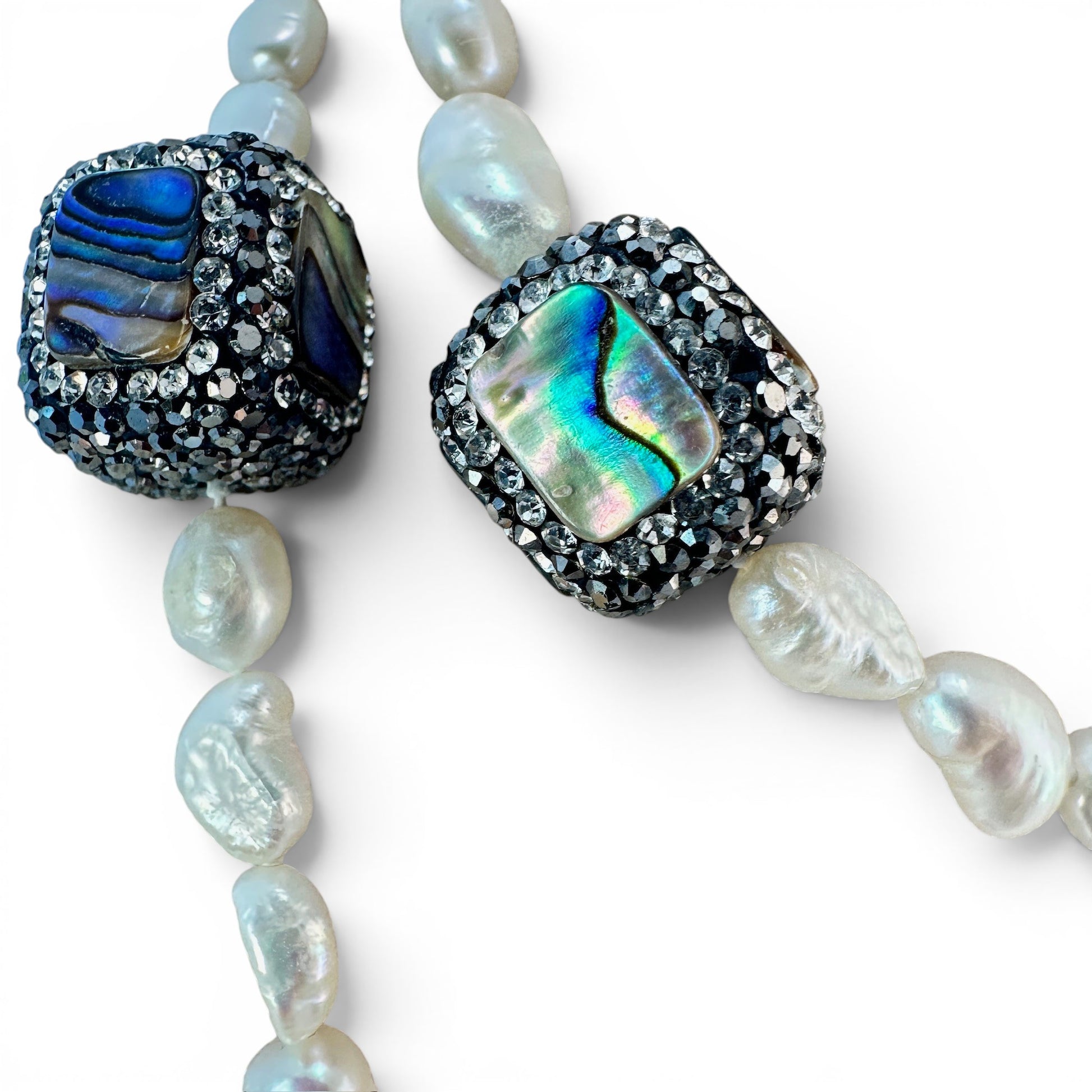 Necklace styled doubled at shorter length showing two-strand wearability with visible pearl and abalone detail