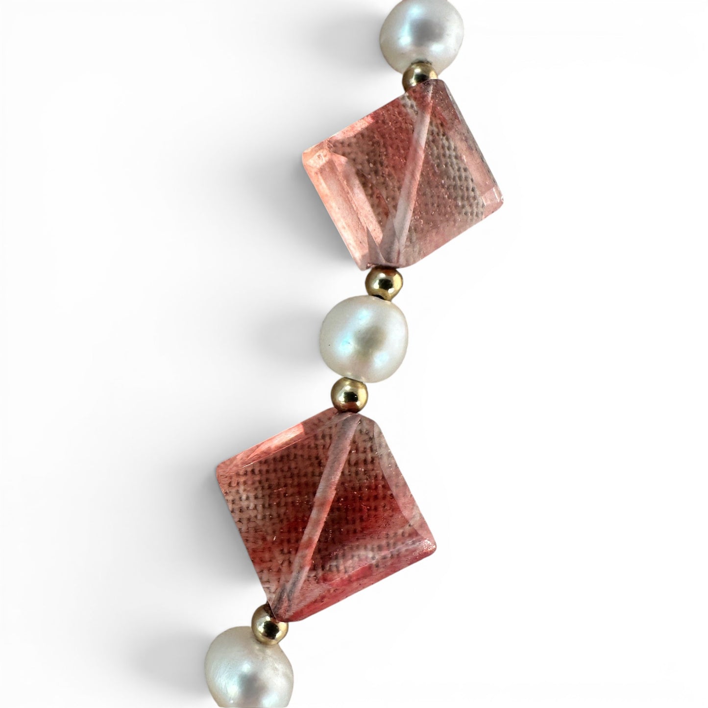 Gold-filled filigree box clasp with lattice decorative front face, necklace laid flat on neutral surface